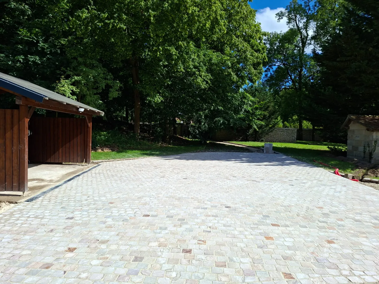 Allée en pavés clairs menant à un garage en bois