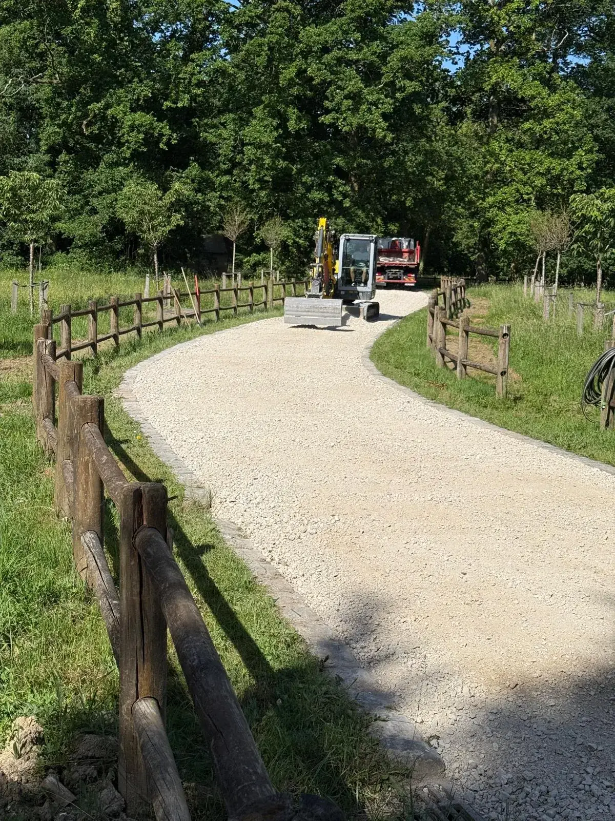 Mini-pelle et camion Créalix sur le chantier d'une allée en gravier