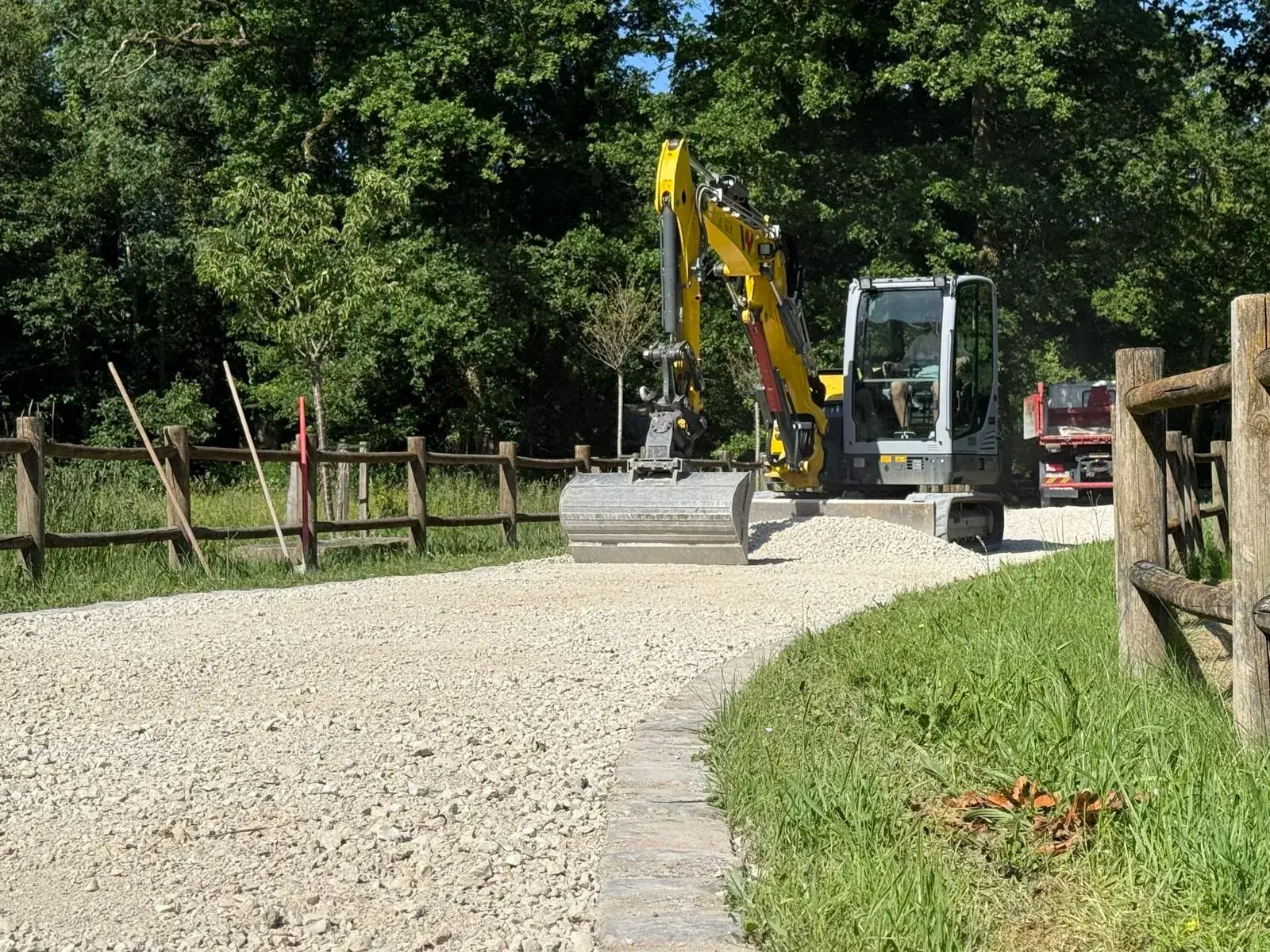 Mini-pelle Créalix à tilt rotateur sur un chantier d'allée