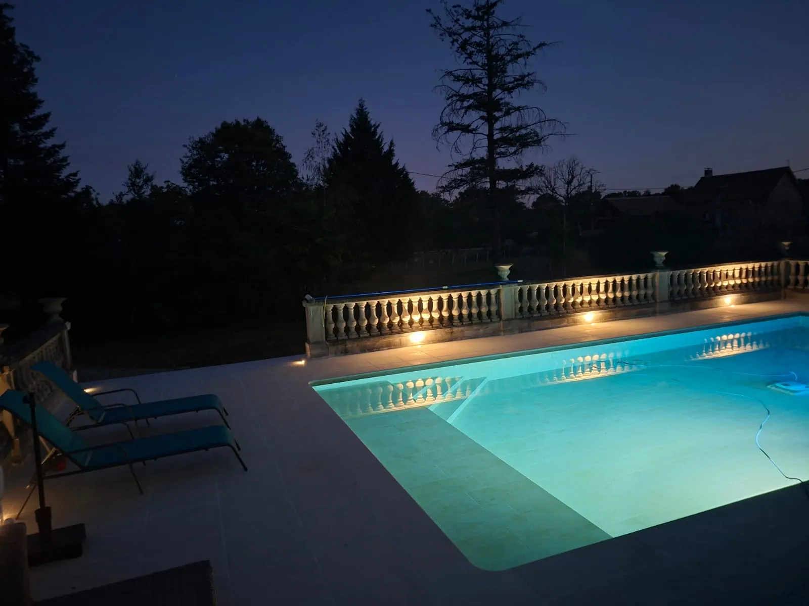 Piscine éclairée de nuit avec sa plage dallée